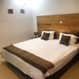 班珠尔Harmony Resort Boutique Hotel的卧室配有一张带白色床单和枕头的大床。