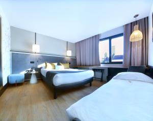 里昂Hôtel Le Roosevelt Lyon的酒店客房,设有两张床和一张沙发
