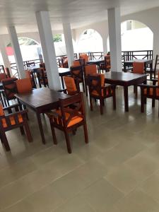 班珠尔Harmony Resort Boutique Hotel的用餐室配有木桌和椅子