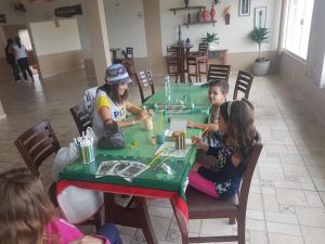 塞拉内格拉Molise Hotel Fazenda的一群坐在桌边玩游戏的儿童