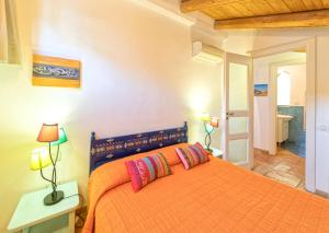伊斯基亚利亚达别墅的一间卧室配有橙色床和两个枕头