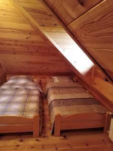 迪瓦伊巴雷Apartmani Milojević的小木屋阁楼内的两张床