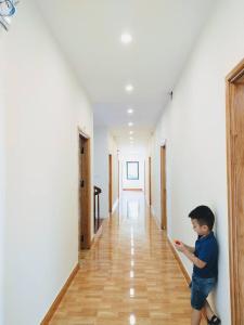 巴位AKU HOUSE Villa Ao vua的一名男孩站在走廊里