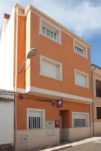 卡斯塔利亚Casa Rural Casole的橙色的建筑,设有窗户和街道