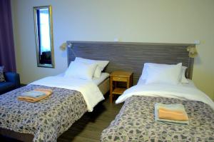 ReisjärviKartanohotelli Saari的两张睡床彼此相邻,位于一个房间里