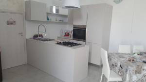 Sogliano CavourLa Casetta的白色的厨房配有炉灶 桌子旁的顶部烤箱