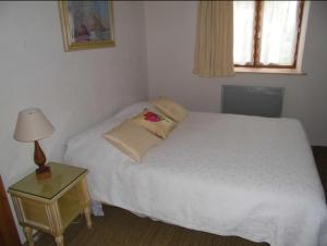 Chassignolles布勒伊旅馆的一间卧室配有一张床和一张带台灯的桌子