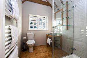 哈洛Pages Hotel and Guesthouse的一间带卫生间和玻璃淋浴间的浴室
