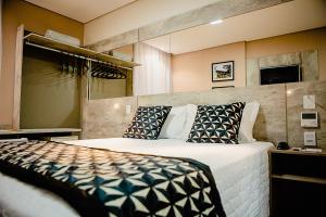 维索萨Bristol Viçosa Hotel的一间卧室配有一张大床和枕头