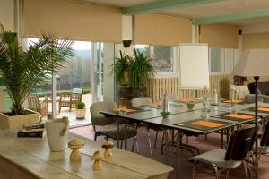 利尼翁河畔勒尚邦贝尔霍里赞酒店的用餐室设有桌椅和窗户。