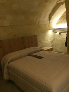 马泰拉Porticina Verde Suite的石屋设有一间带大床的卧室