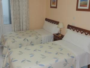 马德里冈萨洛旅馆的两张位于酒店客房的床,配有两张sidx sidx单人床