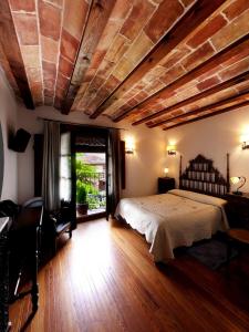 NaldaCasa Rural Torredano的一间卧室设有一张床和木制天花板