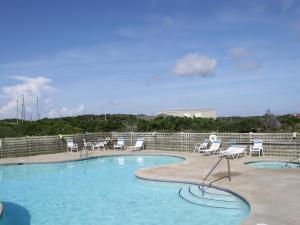 巴克斯顿哈特拉斯汽车旅馆的一个带白色椅子和桌椅的游泳池