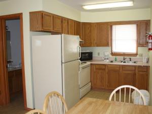 巴克斯顿哈特拉斯汽车旅馆的厨房配有白色冰箱和木制橱柜。