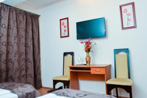 特尔古穆列什Pensiunea Kenza的酒店客房设有一张桌子和一台墙上的电视。
