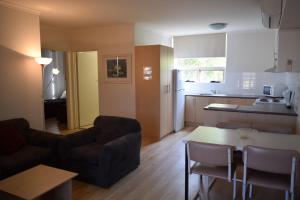 阿德莱德科孚格莱内尔格假日公寓的客厅配有沙发和桌子