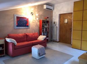 伊夫雷亚La mansarda di Orni的客厅配有红色沙发和书架