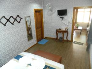 拜县拜县阿拉度假酒店的一间卧室配有一张床、镜子和电视