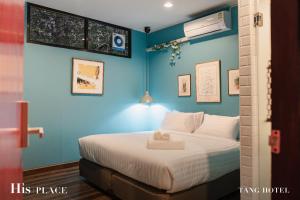 曼谷Tang House的一间卧室配有一张蓝色墙壁的床