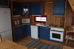科威费耶尔Kvitfjell Alpinhytter Kvitfjellvegen 492的厨房配有蓝色橱柜和白色炉灶烤箱。