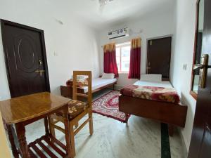 菩提伽耶Rahul Guest House的客房设有两张床、一张桌子和一张桌子。