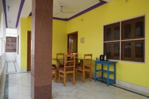 菩提伽耶Rahul Guest House的用餐室设有黄色的墙壁和桌椅