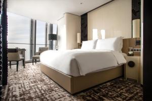 南京Jumeirah Nanjing的卧室设有一张白色大床和大窗户