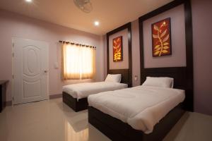 Chiang KhamChiangkham Grand Villa - SHA Certified的一间带两张床的卧室和白色的门