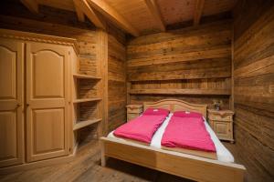 圣坎迪朵格林兹夫山脉天然度假阿格里斯图莫酒店的木制客房内的一间卧室,配有一张床
