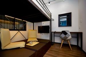 东京043AKIHABARA的一间设有两把椅子、一张桌子和一台电视的房间