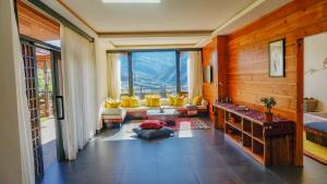 廷布The Postcard Dewa, Thimphu, Bhutan的客厅设有黄色椅子和大窗户