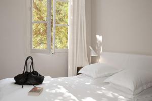 普罗旺斯艾克斯道芬住宿加早餐旅馆的一张白色的床,上面有一个钱包