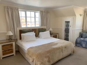 布鲁堡史特兰伯肯黑德庄园旅馆的卧室设有一张白色大床和一扇窗户。
