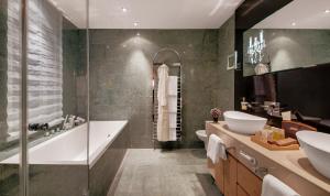 圣莫里茨格堤诺山酒店的一间带水槽、浴缸和卫生间的浴室