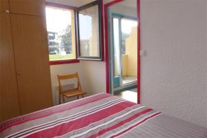 塞尼奥斯Réf 546, Seignosse océan , Appartement classé 2 étoiles , plage et centre à 5mn, 5 personnes的一间卧室配有一张床、一把椅子和窗户。