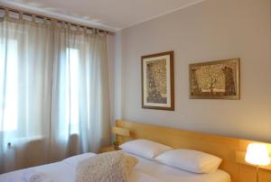 贝尔格莱德Villa Quantum Beograd的卧室配有带白色枕头的床和窗户。