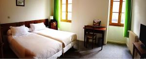 Saint-Dalmas-de-Tende勒普莱勒酒店的一间卧室配有一张床、一张书桌和窗户。