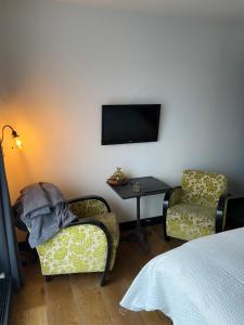 阿姆斯特丹Morpheus的一间卧室配有一张床、一把椅子和电视