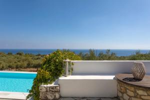 圣尼古拉奥斯Kostas Cottages的游泳池旁的白色浴缸