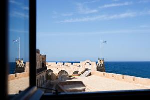 干尼亚阿卡内尔精品酒店的从毗邻大海的建筑物的窗户上可欣赏到风景