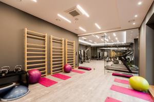 格但斯克Symphony Baltica Towers Aparthotel的健身房设有普拉提设备和粉红色垫子