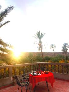 斯库拉Kasbah Elmehdaoui的棕榈树阳台的红色桌椅