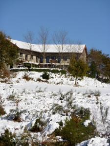 Outeiro奥菲西纳乔宾馆的一座带建筑物的白雪 ⁇ 山上的房子