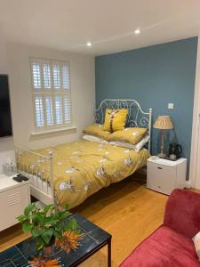 伦敦Stylish Modern Studio, Mock Georgian House, Heart of Trendy Hackney & London的一间卧室配有一张黄色床罩的床