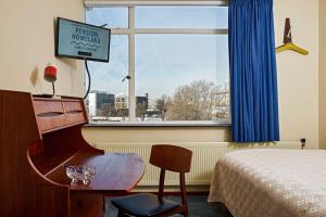 阿姆斯特丹家园酒店的酒店客房设有钢琴、床和窗户。
