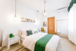 塞雷Grand Lux Apartment的白色卧室设有绿色和白色的床