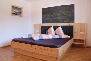 皮茨河谷阿兹尔佳斯特公寓的一张带枕头的木床