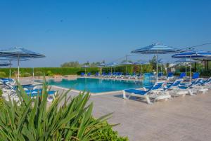 林都斯Rafael Hotel-Adults Only的一个带蓝色椅子和遮阳伞的游泳池