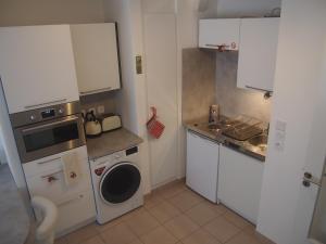 斯特拉斯堡Le Carré des oiseaux的小厨房配有白色橱柜和洗衣机。